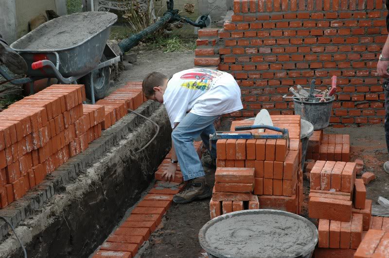 _zijn eerste stenen van zijn leven. aan het metselen.