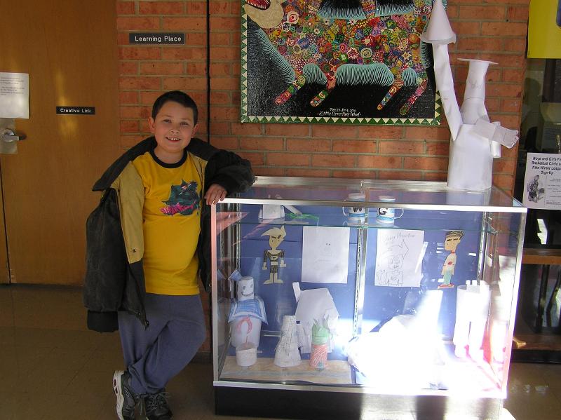 Cade next to his "Artist of the month" display at Alpin...