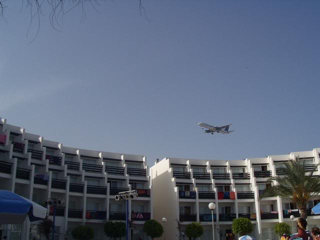 a plane flying over the hotel